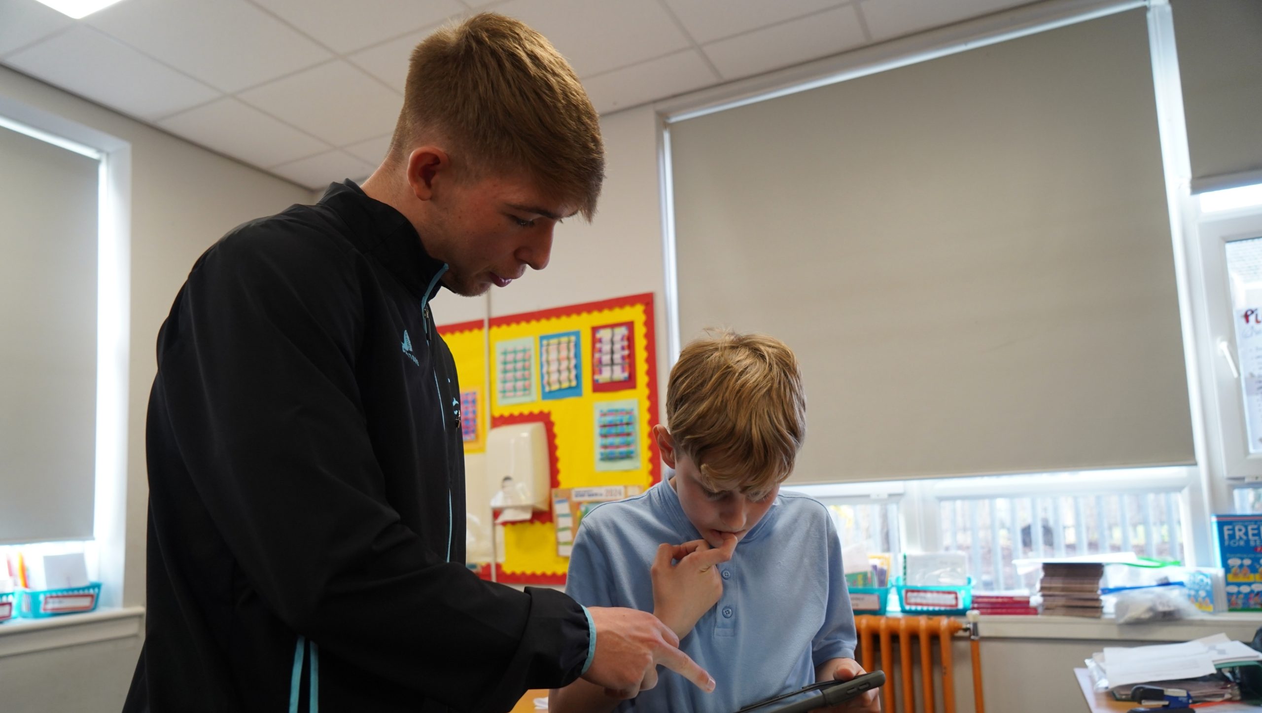 Robbie Fraser helping a pupil with his school work