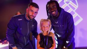 little girl with medal and two players